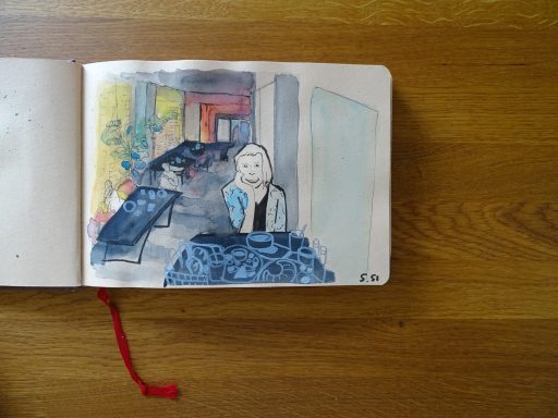 Aqurellzeichnung des Café Das Nest in Mainz, Selbstportrait vor einem Tisch mit Frückstück
